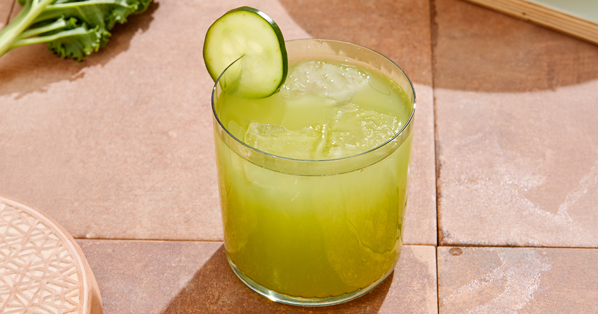 Glass of Rachel's Kitchen Cucumber Ginger Lemonade with ice and a cucumber garnish